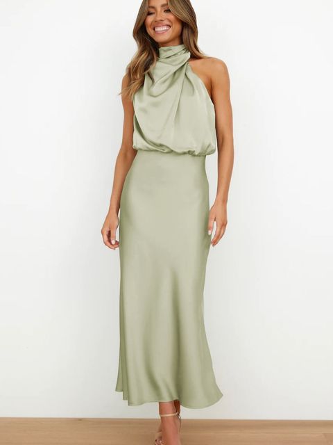 Robe longue verte élégante en satin, sans manches, avec col drapé, portée par une femme souriante. Mode féminine chic et tendance.