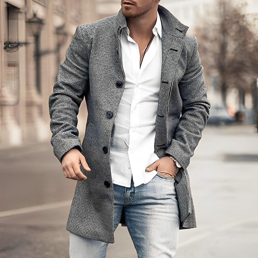 Homme en manteau gris élégant, chemise blanche et jean, marchant en ville. Mode masculine, style urbain chic, tenue automne-hiver tendance.