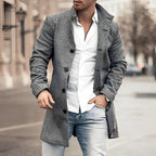 Homme en manteau gris élégant, chemise blanche et jean, marchant en ville. Mode masculine, style urbain chic, tenue automne-hiver tendance.