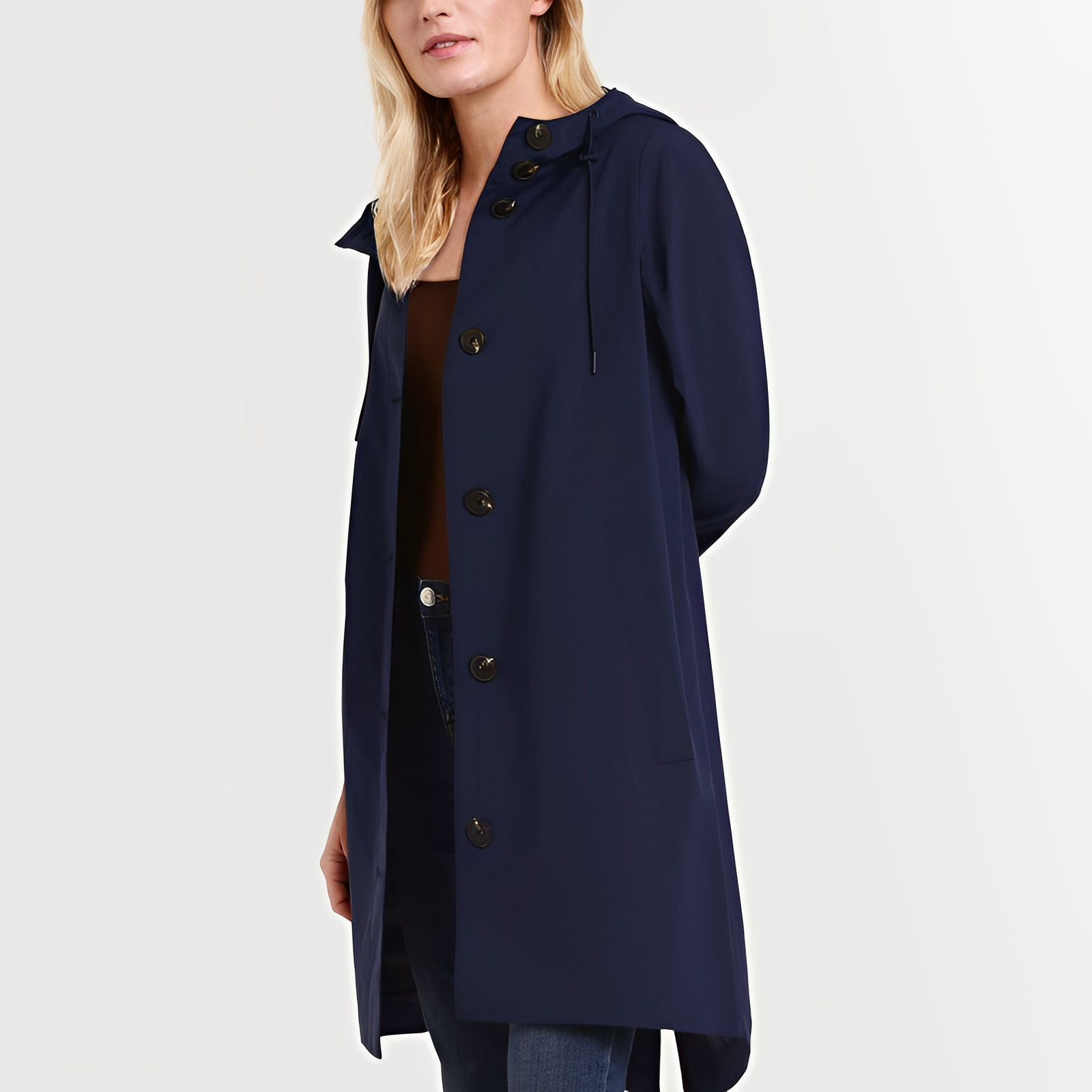 Femme portant un manteau bleu marine élégant avec capuche et boutons noirs, style moderne et chic, mode automne-hiver, tenue décontractée.