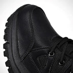 Chaussure de randonnée noire en cuir texturé avec semelle crantée robuste, lacets noirs et œillets métalliques, idéale pour activités extérieures.