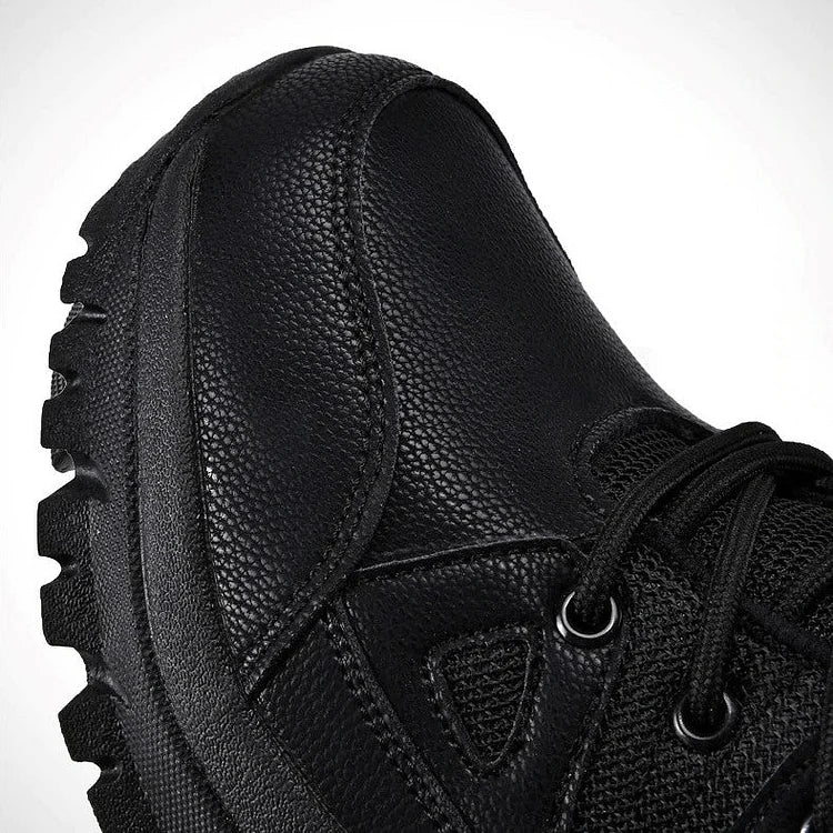 Chaussure de randonnée noire en cuir texturé avec semelle crantée robuste, lacets noirs et œillets métalliques, idéale pour activités extérieures.
