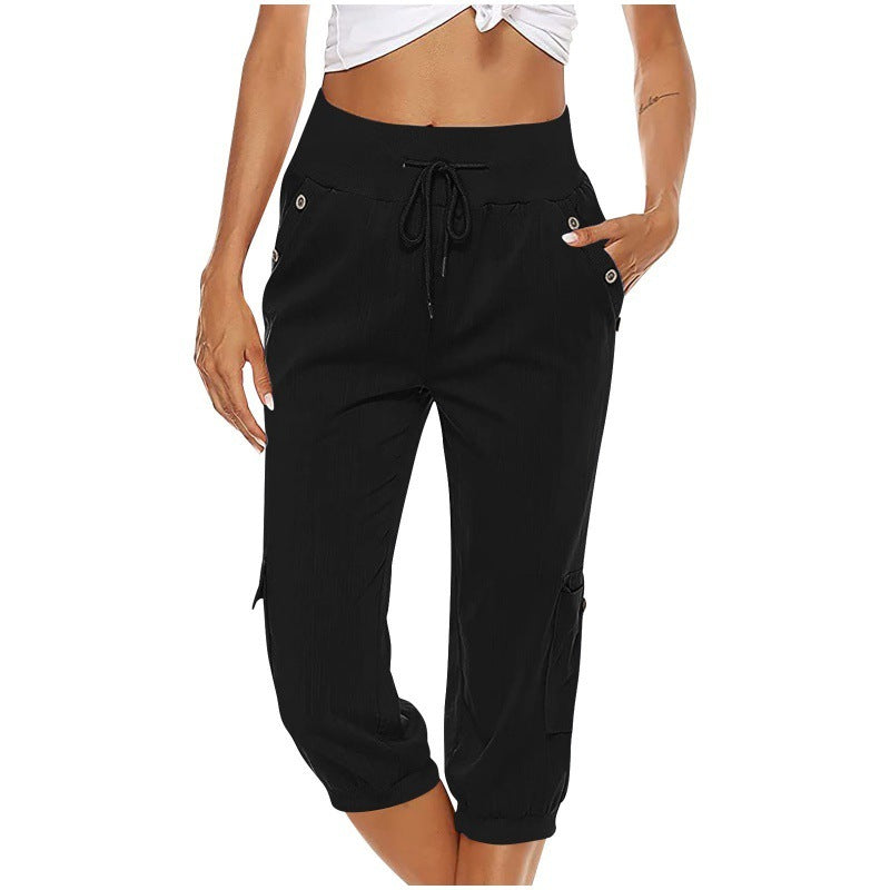 Femme portant un pantalon cargo noir taille haute, avec cordon de serrage et poches, style décontracté. Mode féminine, vêtements confortables.