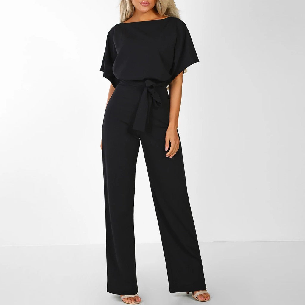 Combinaison noire élégante pour femme avec ceinture, manches courtes et jambes larges, idéale pour une tenue chic et moderne.