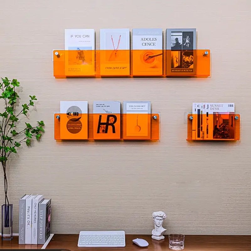 Étagères murales orange avec livres modernes, décor minimaliste, bureau avec clavier, statue blanche et plante verte. Design intérieur contemporain.