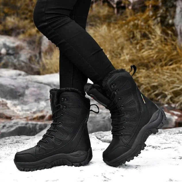 Bottes d'hiver noires imperméables pour femme sur fond de nature rocheuse, idéales pour randonnée et temps froid. Chaussures robustes et confortables.