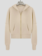 Sweat à capuche beige pour femme, fermeture éclair dorée, poches avant, manches longues, style décontracté, mode automne-hiver.