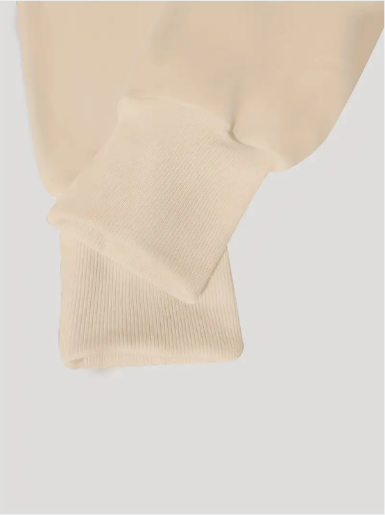 Manche de sweat-shirt beige en coton, gros plan sur le poignet côtelé. Mode décontractée, vêtement confortable, style minimaliste.