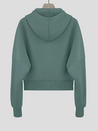 Sweat à capuche vert menthe pour femme, manches longues, coupe ample, style décontracté, idéal pour mode automne-hiver, fond gris clair.