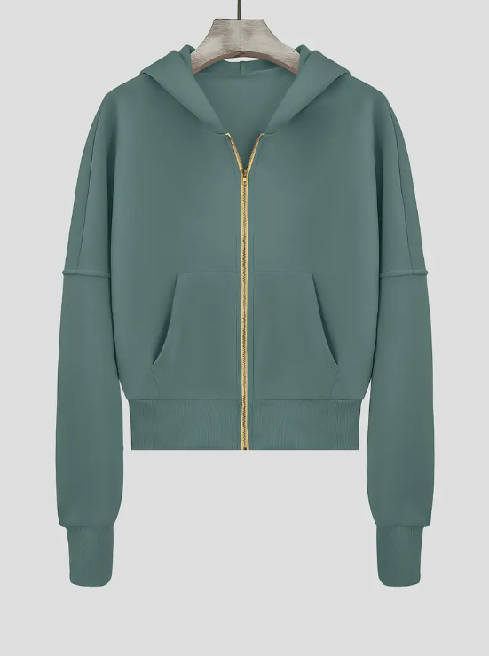 Sweat à capuche vert avec fermeture éclair dorée, manches longues, poches kangourou, suspendu sur cintre. Mode décontractée, vêtement tendance.