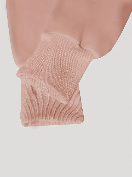 Manches de sweat-shirt rose en coton, gros plan sur les poignets côtelés. Mode décontractée, vêtement confortable, tendance automne-hiver.