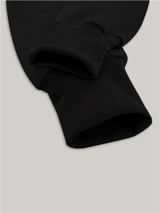 Manche de sweat-shirt noir en coton, gros plan sur le poignet côtelé. Mode décontractée, vêtement basique, style minimaliste.