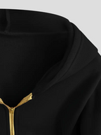 Veste à capuche noire avec fermeture éclair dorée, style moderne et minimaliste, mode urbaine, vêtement tendance pour homme et femme.