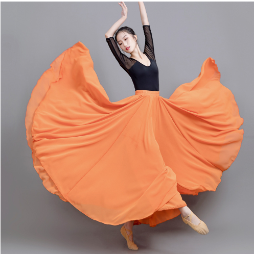 Danseuse en tenue noire et jupe orange fluide, exécutant un mouvement gracieux de ballet sur fond gris. Ballet, danse classique, élégance.