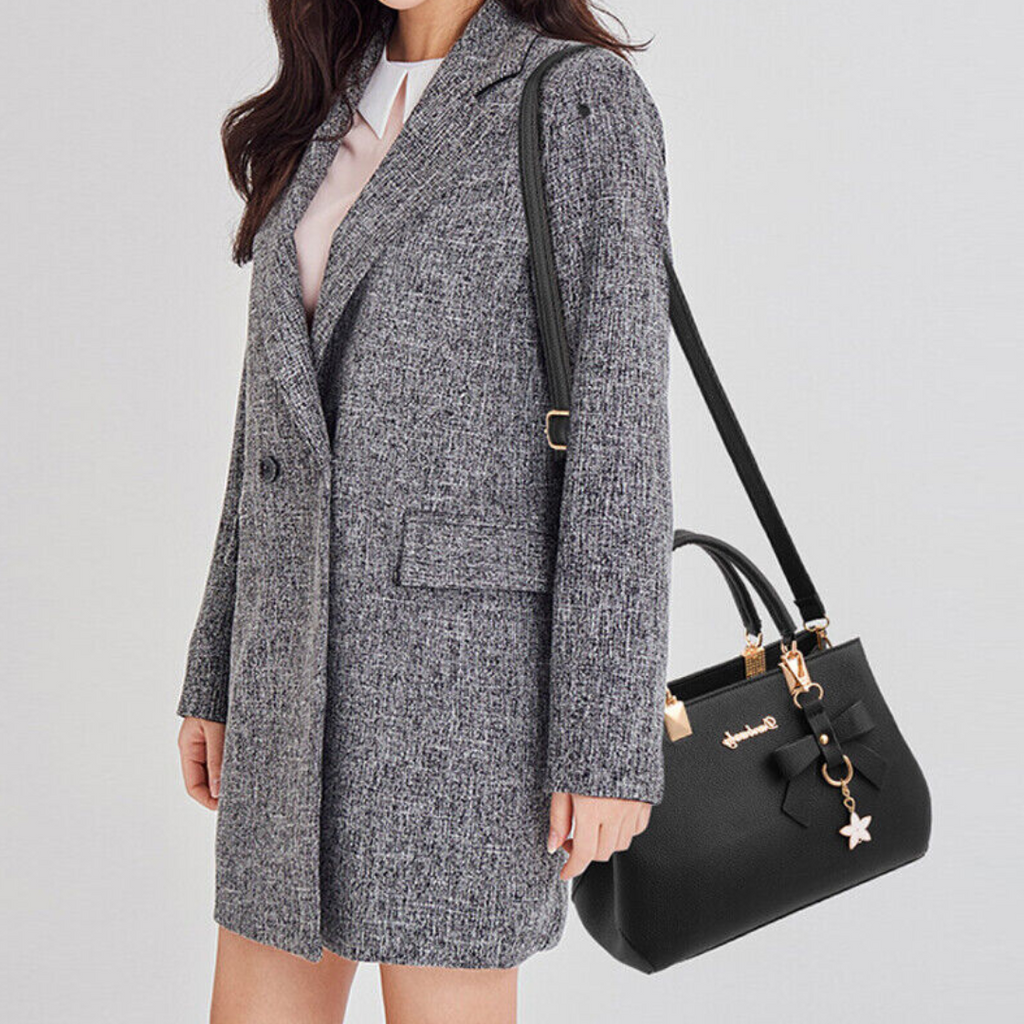 Femme en manteau gris élégant portant un sac à main noir chic avec breloque étoile, mode automne-hiver, accessoires tendance pour femmes.