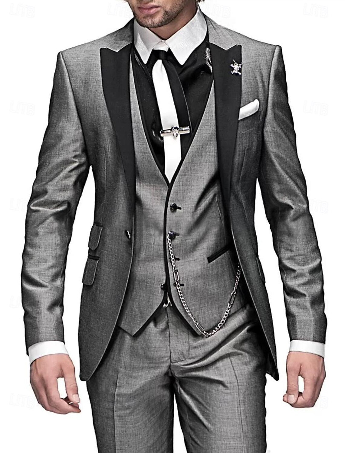 Costume trois pièces gris élégant pour homme, avec cravate noire et chaîne argentée, idéal pour mariage ou événement formel.