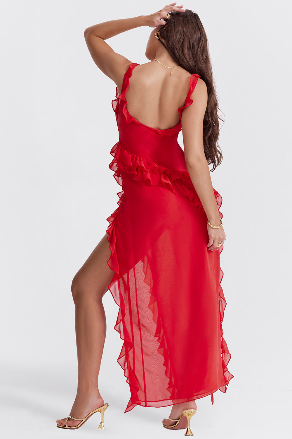 Robe rouge élégante avec volants, fendue sur le côté, portée par une femme de dos. Mode féminine, tenue de soirée glamour, style chic.