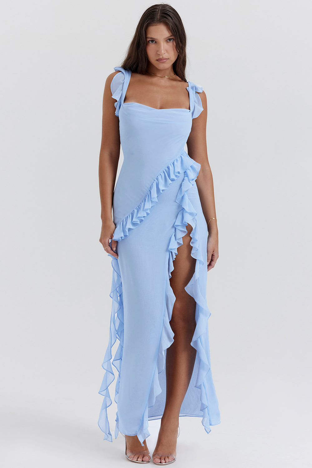 Robe longue bleue à volants, fendue sur le côté, portée par une femme. Mode élégante, tenue de soirée, style chic et moderne.