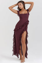 Robe longue bordeaux à volants, élégante et fluide, portée par une femme posant avec confiance. Mode féminine, tenue de soirée chic.