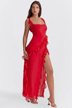 Robe rouge élégante avec volants, fendue sur le côté, portée par une femme. Mode féminine, tenue de soirée chic, style glamour.