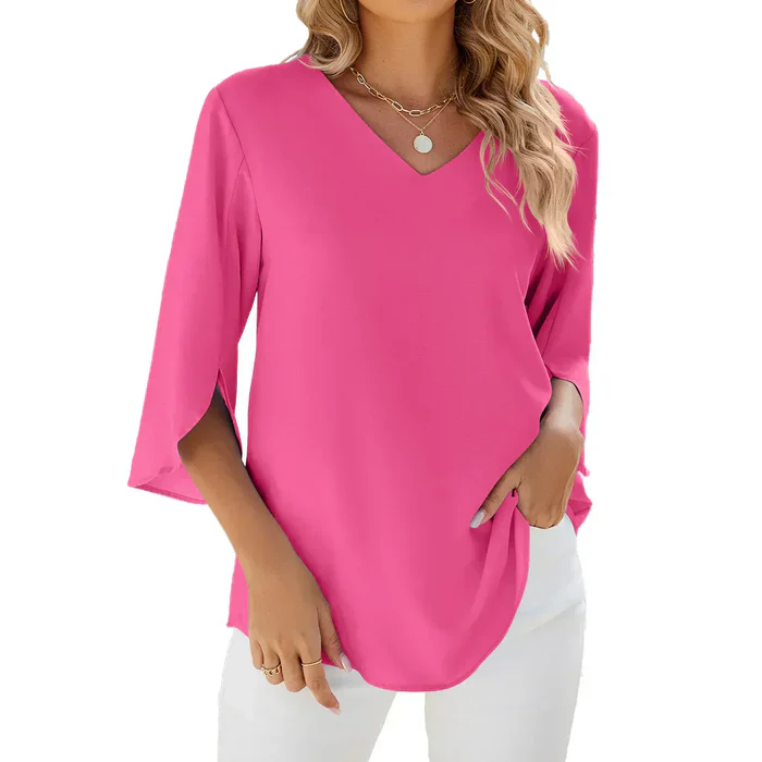 Blouse rose à manches trois-quarts, col en V, portée par une femme avec un collier doré. Mode féminine élégante et tendance.