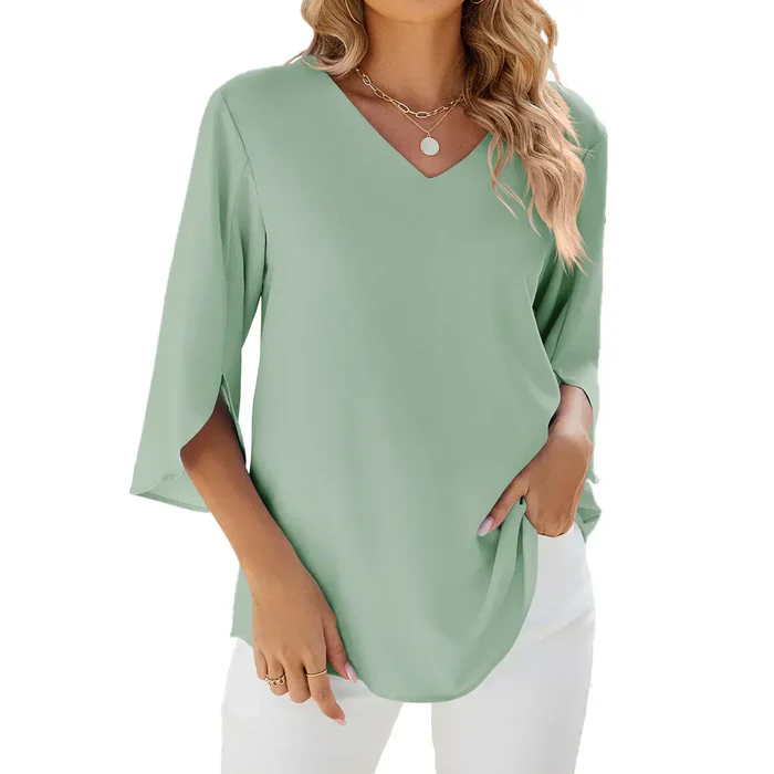 Blouse verte à manches trois-quarts, col en V, portée par une femme avec un collier doré, style décontracté et élégant, mode féminine tendance.