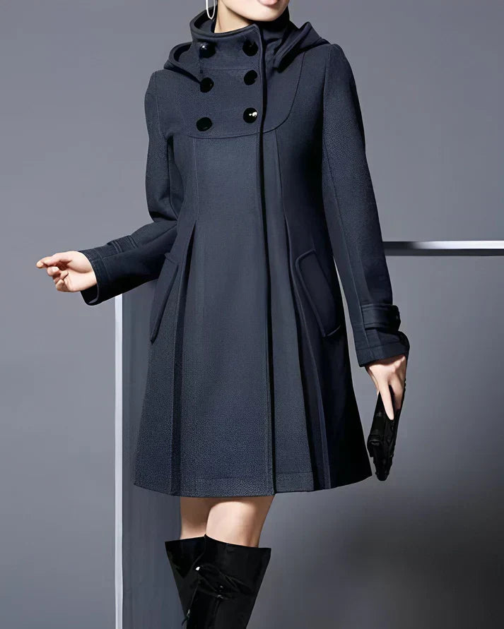 Manteau femme élégant noir avec capuche, boutons décoratifs, poches latérales, porté avec bottes noires. Mode hiver chic et moderne.