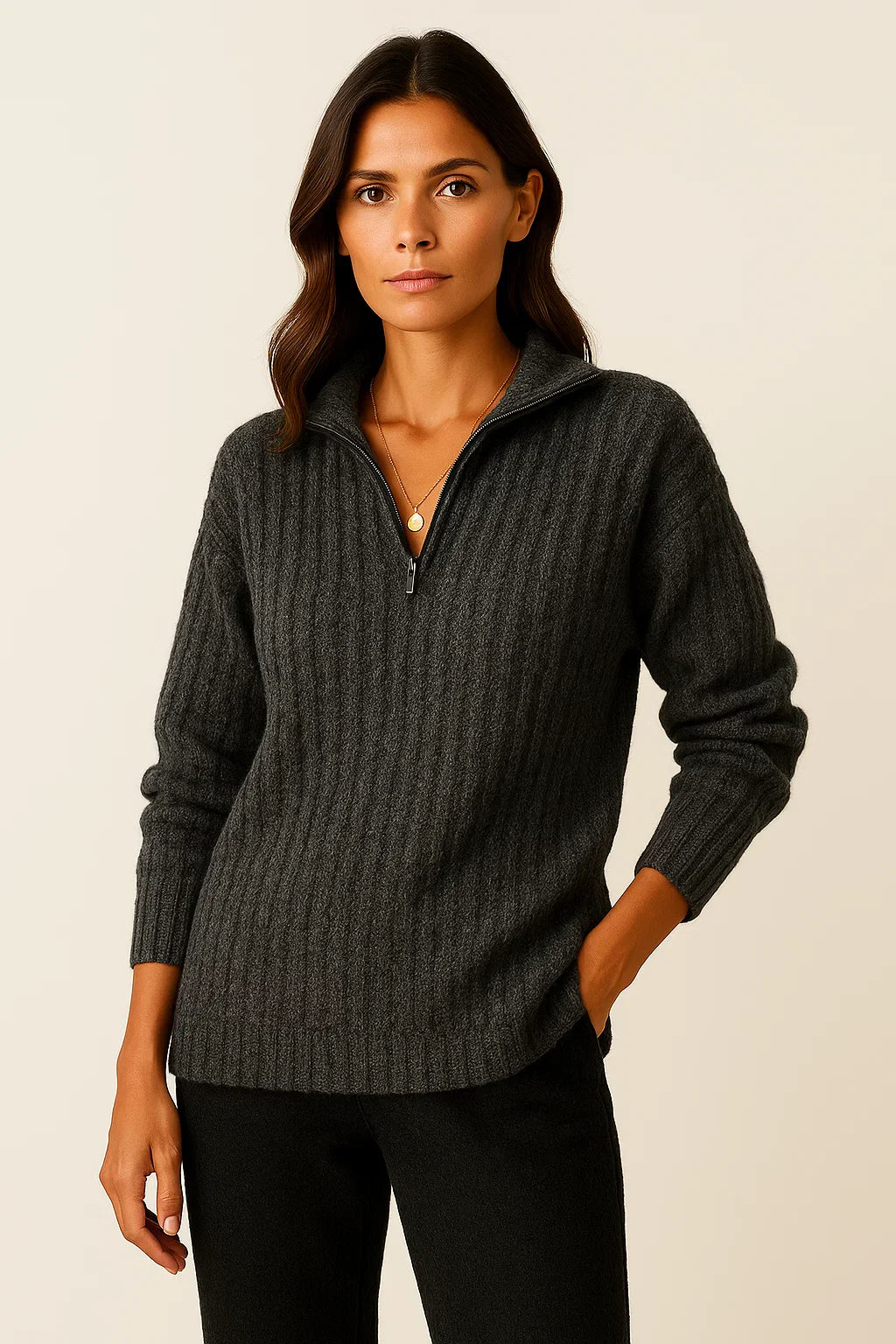 Femme portant un pull gris à col zippé, manches longues, en laine côtelée. Mode automne-hiver, style décontracté et élégant.