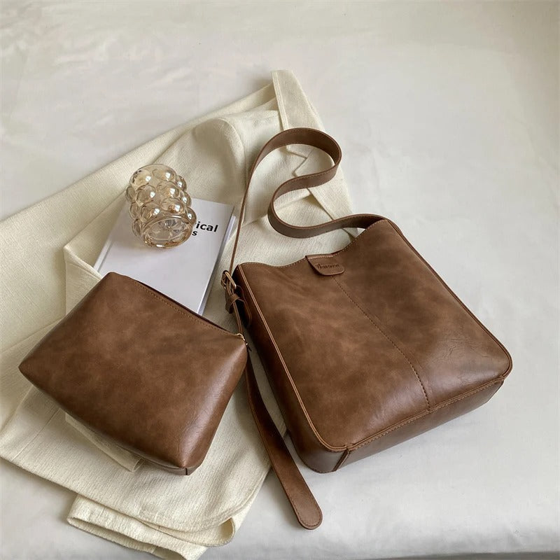 Sac à main en cuir marron avec pochette assortie sur fond blanc, design élégant et moderne, accessoire de mode tendance pour femmes.