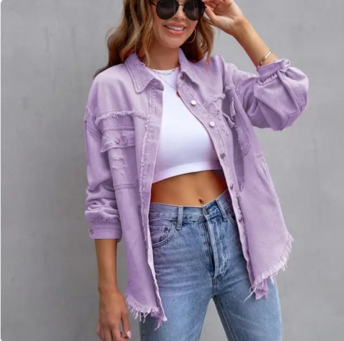 Femme souriante portant une chemise en jean lavande effilochée, un crop top blanc et un jean bleu. Mode décontractée, tendance printemps-été.