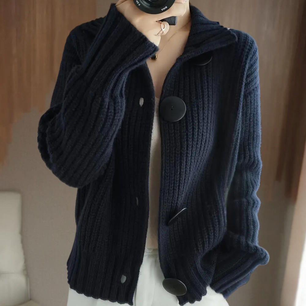 Veste en tricot bleu marine avec grands boutons noirs, portée par une personne. Mode automne-hiver, style décontracté et élégant.