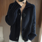 Veste en tricot bleu marine avec grands boutons noirs, portée par une personne. Mode automne-hiver, style décontracté et élégant.