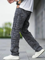 Pantalon cargo en jean gris foncé pour homme, style décontracté, avec baskets blanches. Mode urbaine tendance, idéal pour un look moderne.