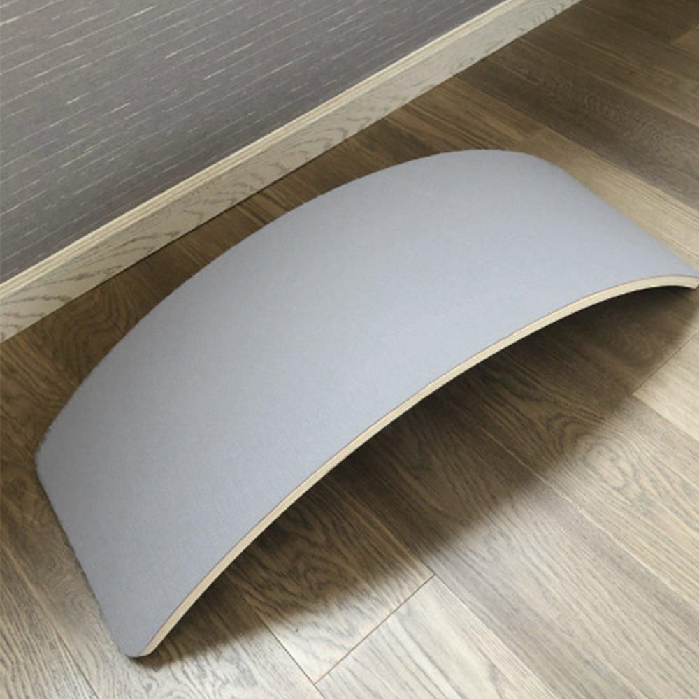 Planche d'équilibre en bois courbé sur sol en bois, accessoire de fitness pour exercices d'équilibre et de posture, design minimaliste et moderne.