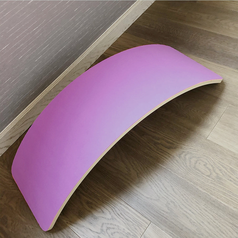 Planche d'équilibre en bois rose sur sol en bois, outil de fitness pour yoga et exercices d'équilibre, design moderne et minimaliste.