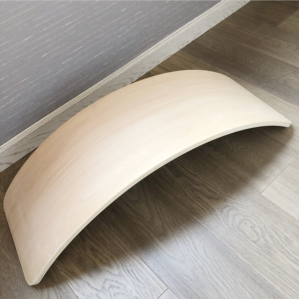 Planche d'équilibre en bois sur sol en bois clair, accessoire de fitness pour améliorer l'équilibre, la coordination et la force musculaire.