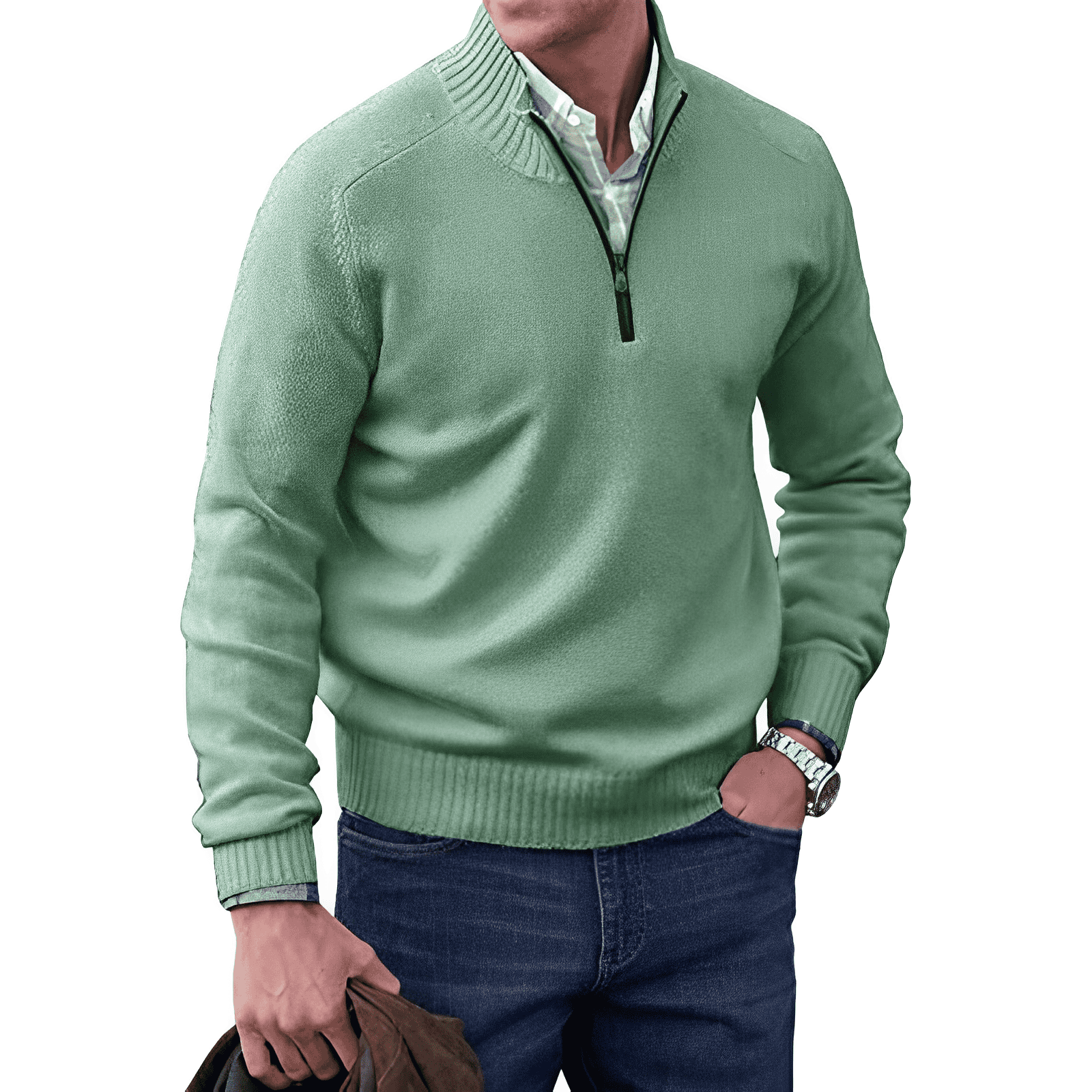 Homme portant un pull vert à col zippé, chemise blanche, jean bleu, tenant une veste marron. Mode masculine élégante et décontractée.
