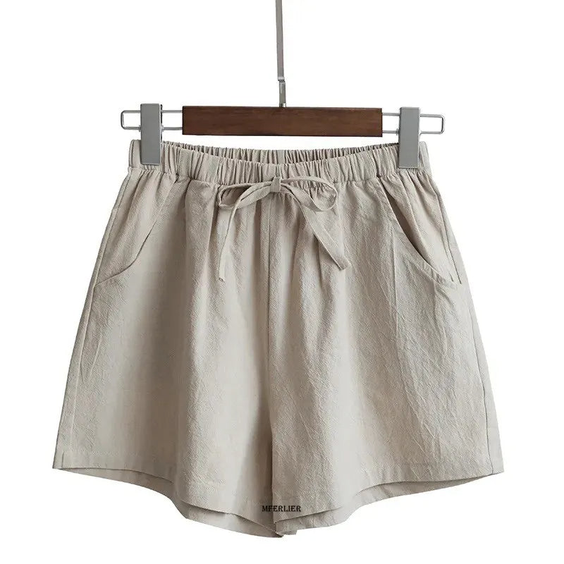 Short beige en lin suspendu, avec poches latérales et ceinture à nouer. Mode été, vêtement léger et confortable pour femmes.