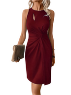 Robe rouge élégante sans manches avec détail torsadé, portée par une femme tenant une pochette beige. Mode féminine chic et tendance.