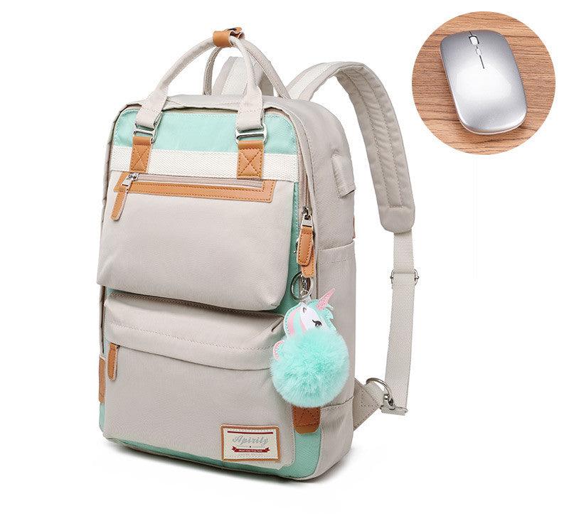 Sac à dos beige et vert menthe avec porte-clés licorne, poches multiples et détails en cuir. Souris sans fil grise sur table en bois.