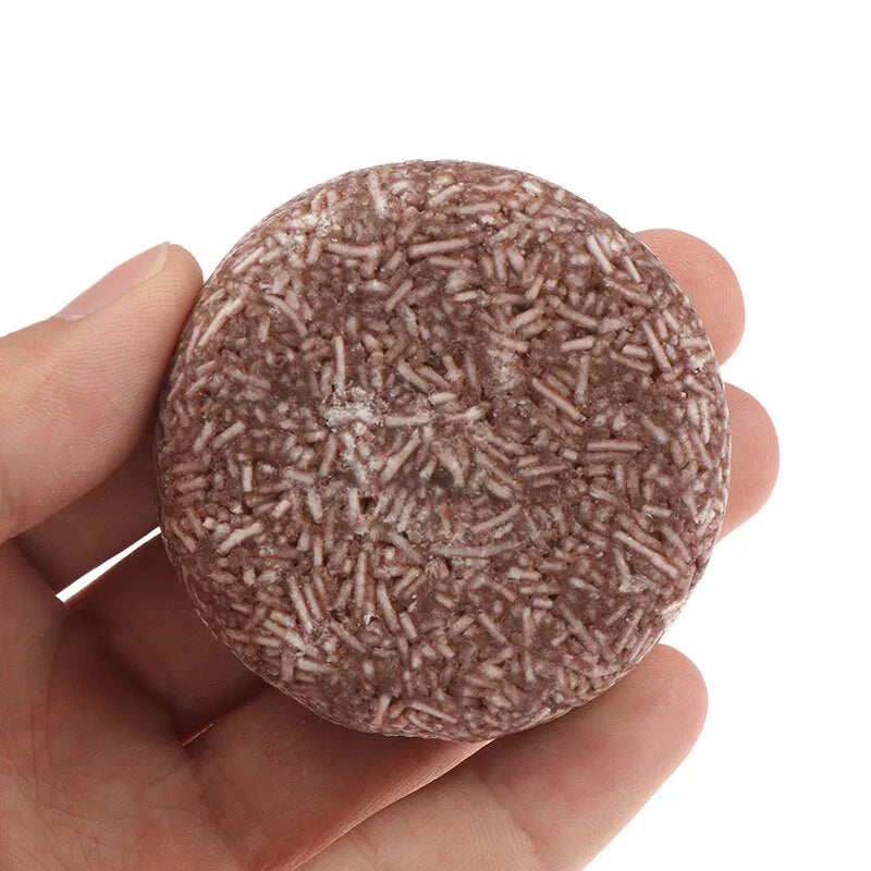 Main tenant un shampoing solide brun texturé, écologique et zéro déchet. Produit capillaire naturel, tendance et durable pour soins cheveux.