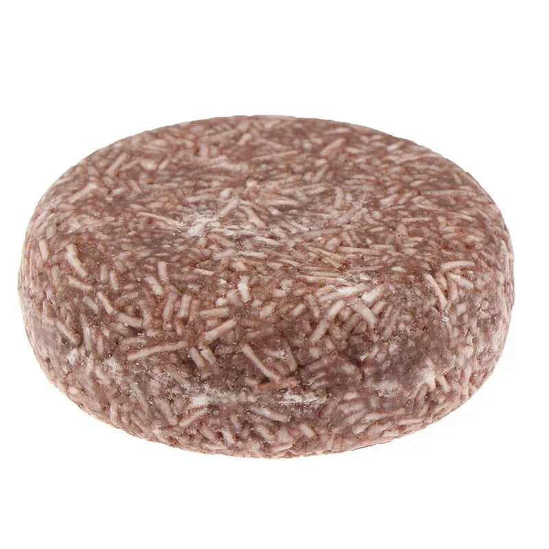 Shampoing solide naturel, rond et marron, enrichi en ingrédients bio pour cheveux secs. Produit écologique et zéro déchet.