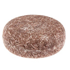 Shampoing solide naturel, rond et marron, enrichi en ingrédients bio pour cheveux secs. Produit écologique et zéro déchet.