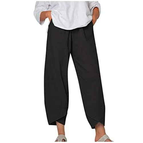 Pantalon noir ample pour femme, style décontracté, avec taille élastique et poches, porté avec une chemise blanche. Mode féminine confortable.