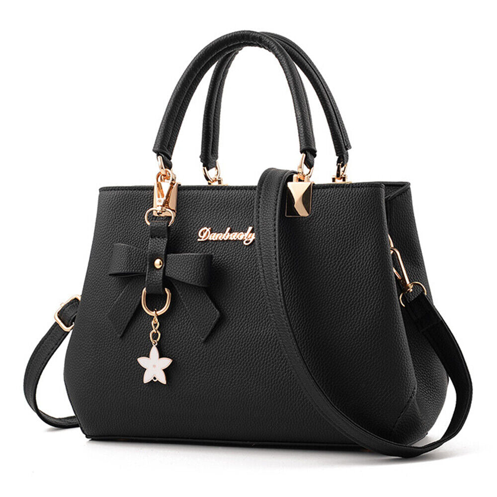 Sac à main noir élégant avec bandoulière, orné d'un nœud et d'un pendentif étoile. Accessoire mode femme chic et tendance.