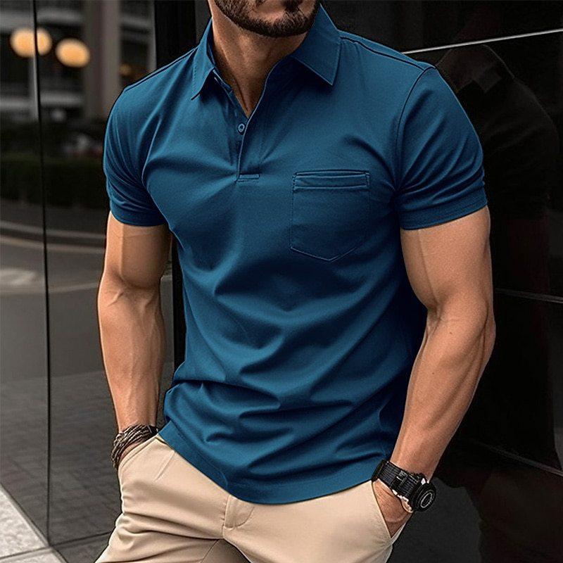 Homme portant un polo bleu ajusté, manches courtes, avec poche poitrine, montre noire, bracelet, pantalon beige, en ville. Mode masculine élégante.