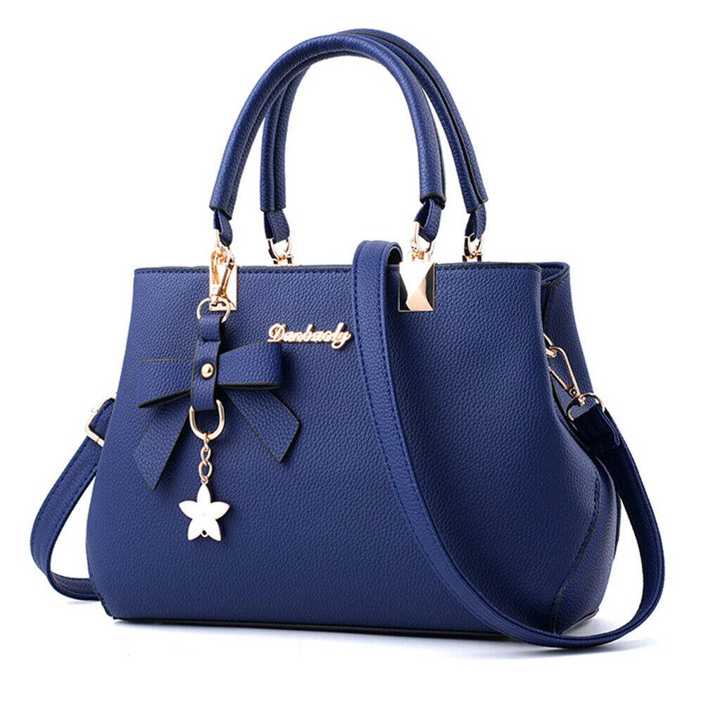 Sac à main bleu élégant avec bandoulière, orné d'un nœud et d'un pendentif étoile. Accessoire mode femme chic et tendance.