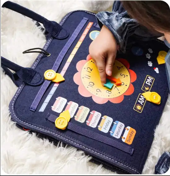Enfant jouant avec un tableau éducatif en tissu bleu, montrant une horloge et des jours de la semaine. Jeu éducatif, apprentissage du temps.