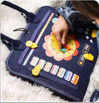 Enfant jouant avec un tableau éducatif en tissu bleu, montrant une horloge et des jours de la semaine. Jeu éducatif, apprentissage du temps.