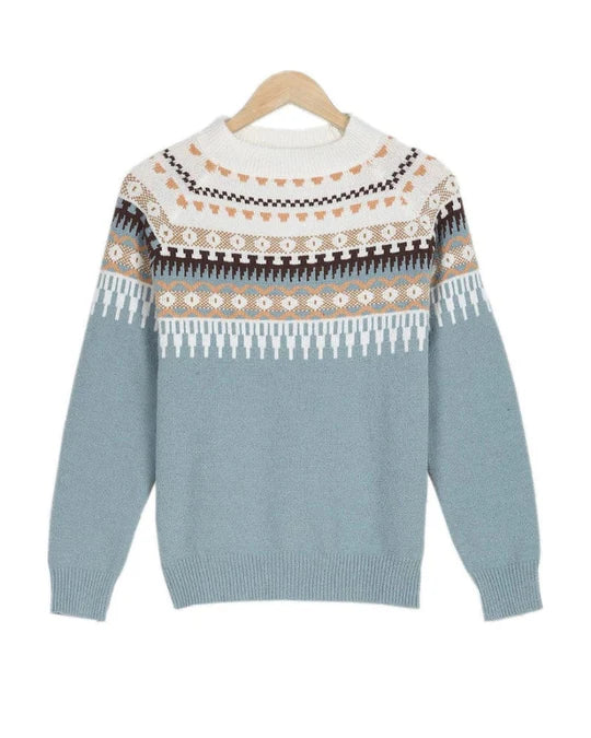 Pull-over en laine bleu avec motifs nordiques blancs et marron, col rond, manches longues, suspendu sur un cintre en bois. Mode hiver tendance.